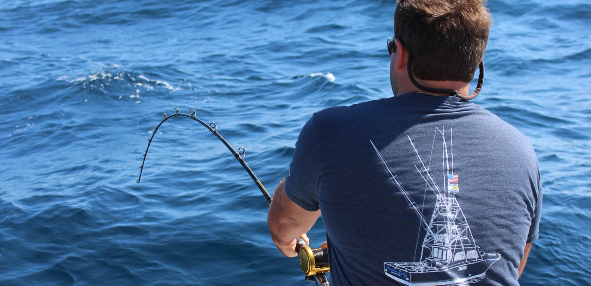 man reeling in a fish